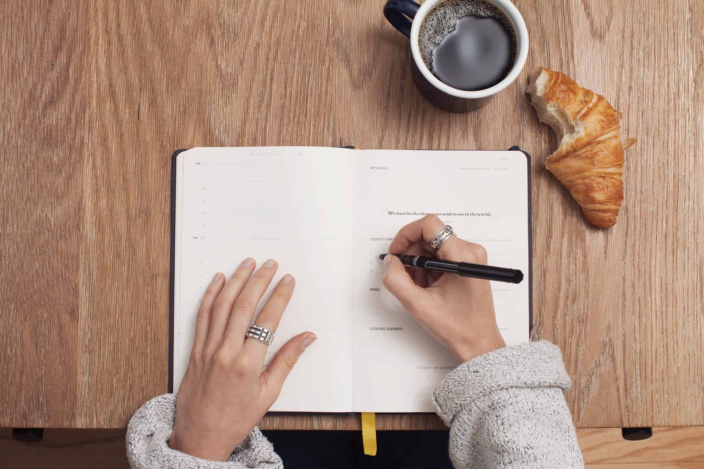 a person writing on a planner